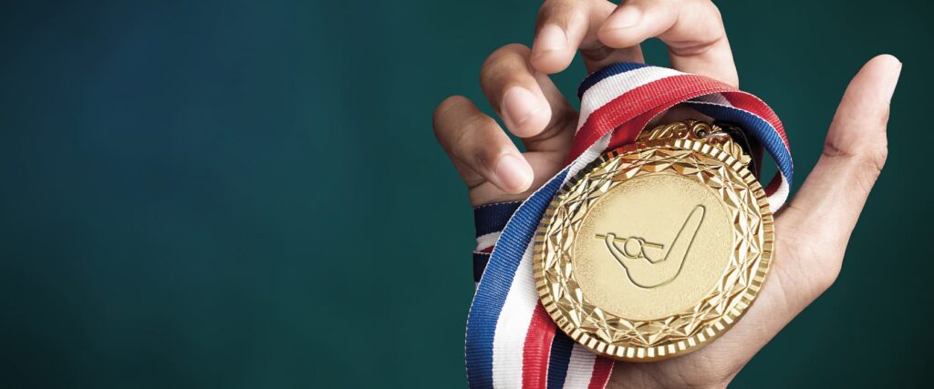 Picture of a medal being held symbolizing a will-to-succeed as a brand value at GOLDBECK SOLAR.