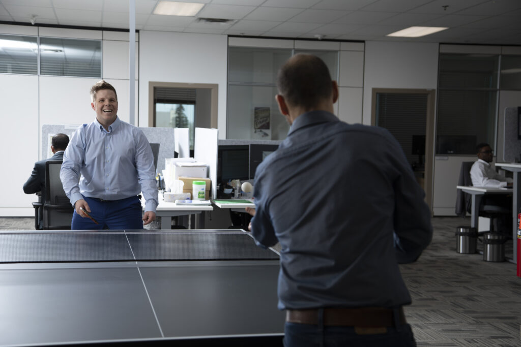 Two GOLDBECK SOLAR colleagues playing a ping pong game.