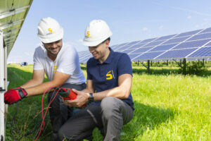 Two GOLDBECK SOLAR team members working together on a solar farm's maintenance